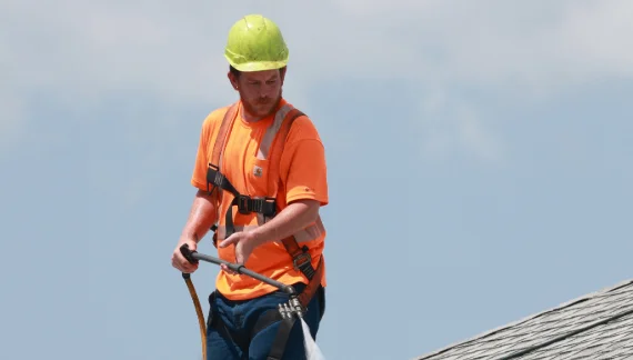 An employee spraying a residential roof