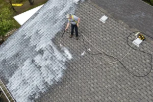 An employee applying the roof rejuvenation product on a residential roof in Lancaster, PA