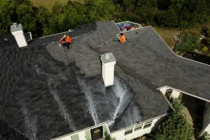 Technicians spraying an eco-friendly roof rejuvenation treatment on aging asphalt roof